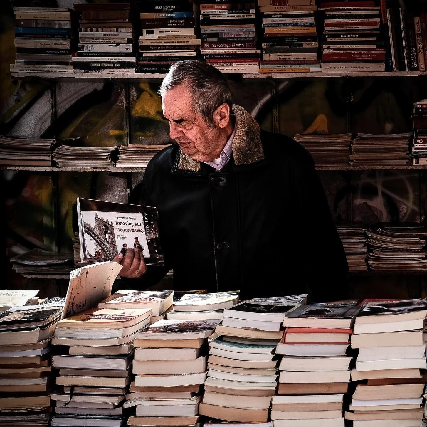 Moški pregleduje stare knjige.