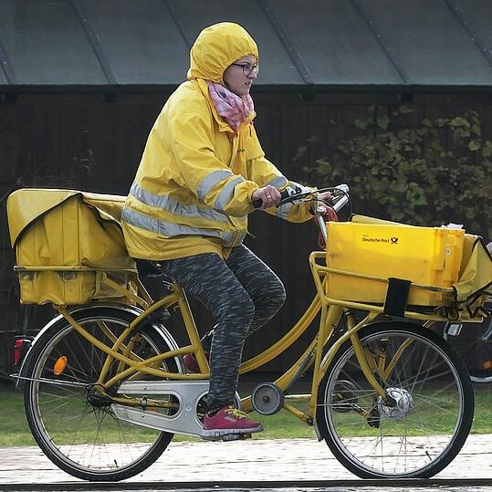 Ženska pismonoša na rumenem kolesu