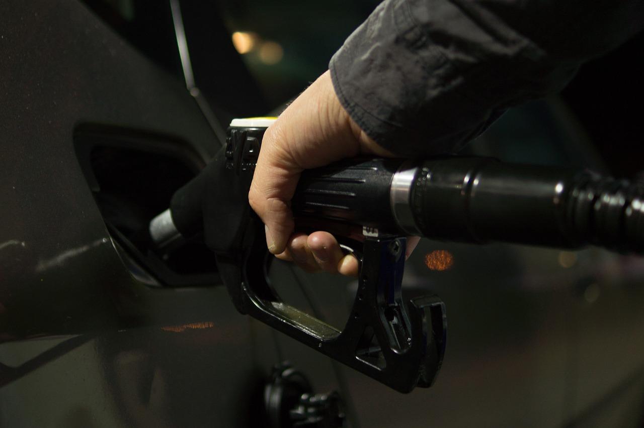 Moški s pumpo za točenje goriva naliva gorivo v avtomobil 