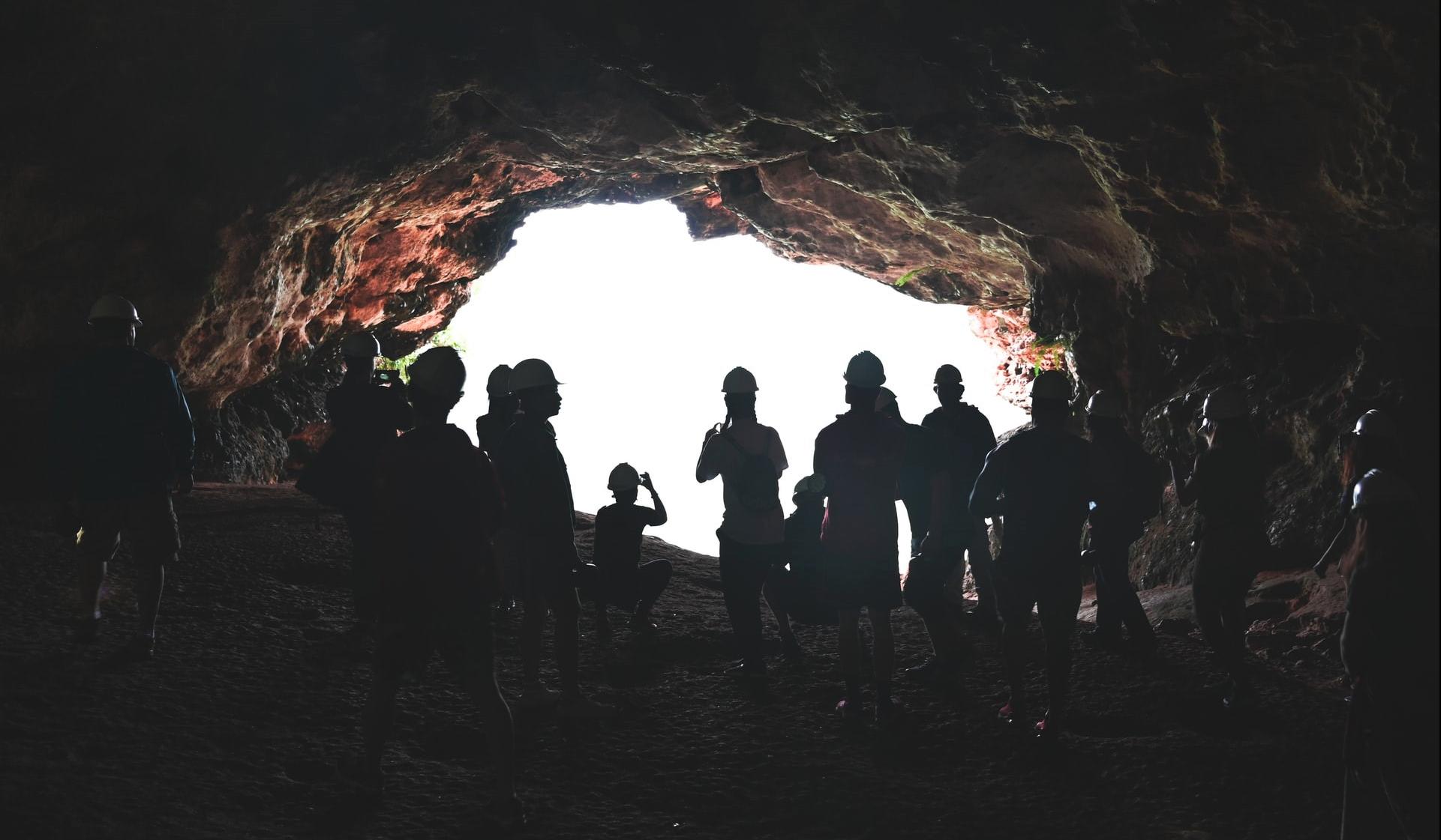 Skupina ljudi v jami ob odprtini.